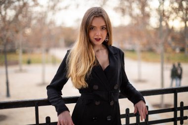 Bir çit oturan bir parkta poz güzel model kadın