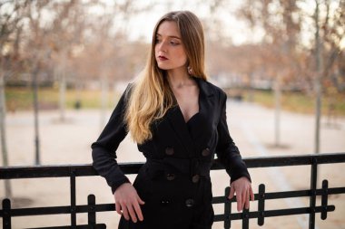 Bir çit oturan bir parkta poz güzel model kadın