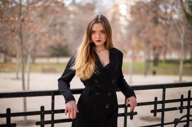 Bir çit oturan bir parkta poz güzel model kadın