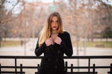 Bir çit oturan bir parkta poz güzel model kadın