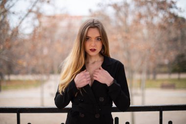 Bir çit oturan bir parkta poz güzel model kadın