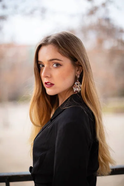 Bir çit oturan bir parkta poz güzel model kadın