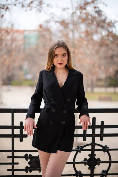 Bir çit oturan bir parkta poz güzel model kadın