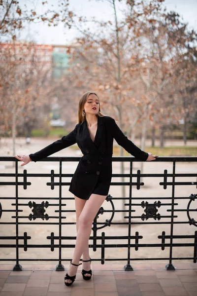 Bir çit oturan bir parkta poz güzel model kadın