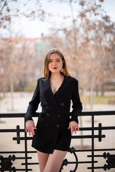 Bir çit oturan bir parkta poz güzel model kadın