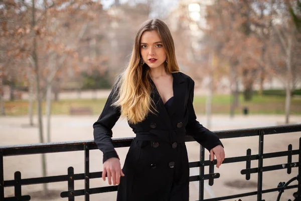 Bir çit oturan bir parkta poz güzel model kadın