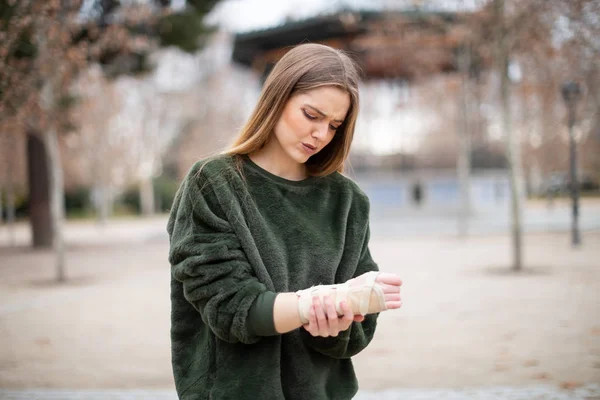 Belle Jeune Femme Tenue Élégante Fronçant Les Sourcils Touchant Bandage — Photo