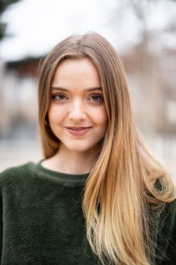 Sonbaharda bir parkta mutlu gülümseyen genç sarışın kadın Portresi