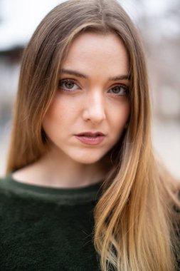 Sonbaharda bir parkta mutlu gülümseyen genç sarışın kadın Portresi