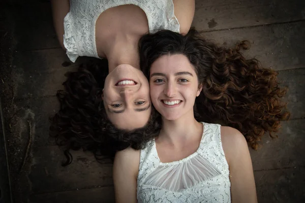 드레스를 아름다운 쌍둥이 자매의 위에서 카메라에 바닥에 반대편에 있습니다 — 스톡 사진