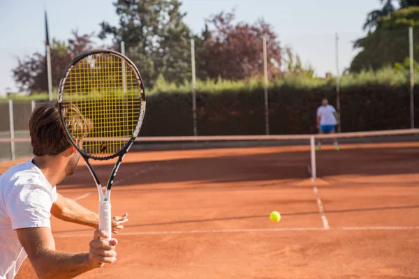 Öğleden sonra sahada oynayan profesyonel tenis oyuncu adam.