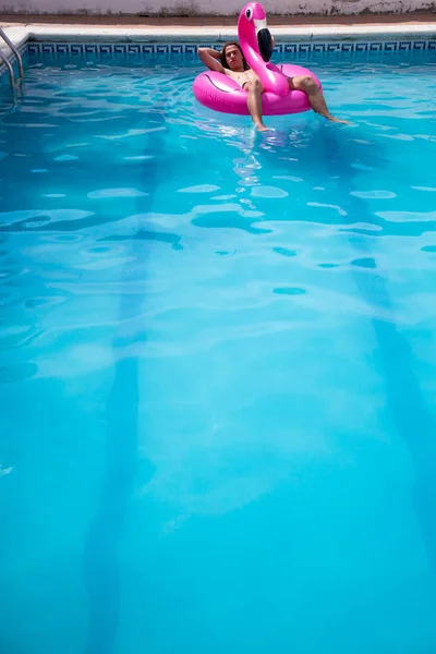 Hombre Joven Flotando Flamenco Inflable Una Piscina Azul Día Soleado — Foto de Stock