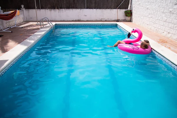 Jovem Flutuando Flamingo Inflável Uma Piscina Azul Dia Ensolarado Férias — Fotografia de Stock