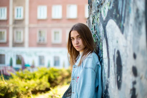 Красивая Молодая Женщина Повседневной Одежде Опирающаяся Выветрившуюся Стену Граффити Стоя — стоковое фото