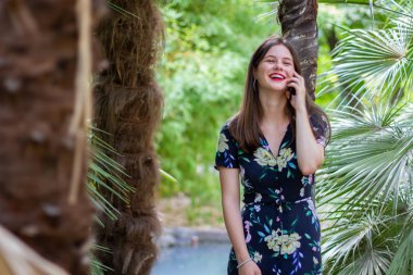 Parkta akıllı telefonda gülen ve konuşan kadın