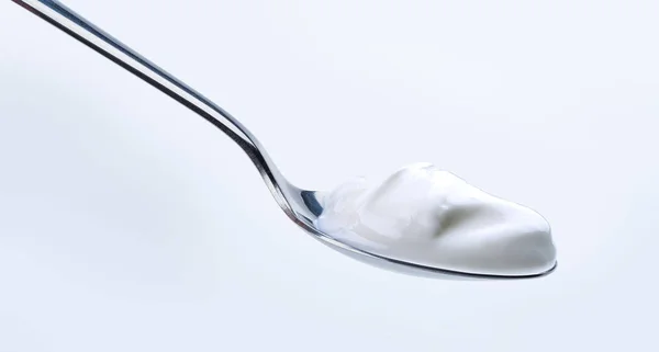 Yoghurt on silver spoon — Stock Photo, Image