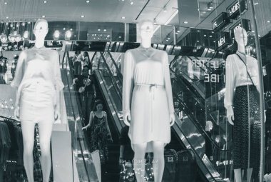 Ho Chi Minh City, Vietnam - 8 Ocak 2019: Alışveriş merkezinin içi kadın mankenli yürüyen merdivenlerle (bulanık) ve Vincom Center 'da birden fazla neon ışığı ve yansıması olan insanlarla dolu.