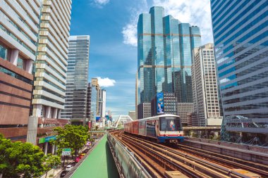 Bangkok - 9 Haziran 2019: BTS treni şehir merkezindeki gökdelenler arasında mavi gökyüzüne karşı ilerliyor. Bangkok Toplu Taşımacılık Sistemi günde 700 binden fazla kişiyi naklediyor.