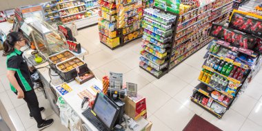 Ho Chi Minh City, Vietnam - 4 Mayıs 2019: Bir Family Mart süpermarketinin iç mekanı, bir mağaza asistanı, bir fast food ayrılışı ve mallarla dolu raflar.