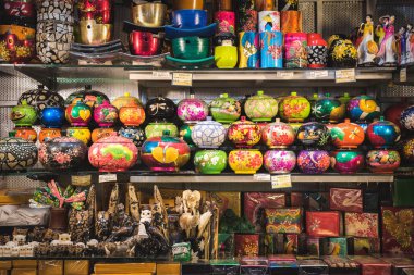 Ho Chi Minh City, Vietnam - 8 Nisan 2019: Ben Thanh Market 'teki bir dükkanda raflarda hediyelik eşya bolluğu (tabutlar, heykeller, bardaklar vs.). Ben Thanh Market turistler arasında popüler bir alışveriş merkezidir..