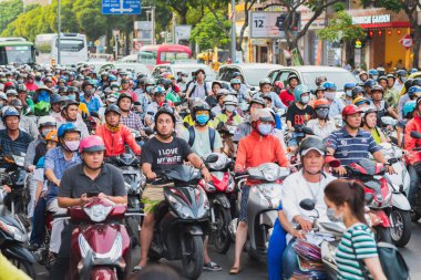 Ho Chi Minh Şehri, Vietnam - 09 Nisan 2019: kalabalık bir motosiklet sürücüsü yoğun saatlerde kavşakta trafik ışığını bekliyor.