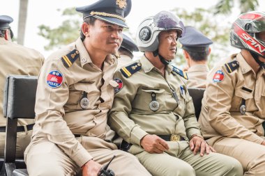 Phnom Penh, Kamboçya - 17 Ocak 2019: Kamboçyalı bir grup polis kamyonetin bulunduğu bankta oturuyor.