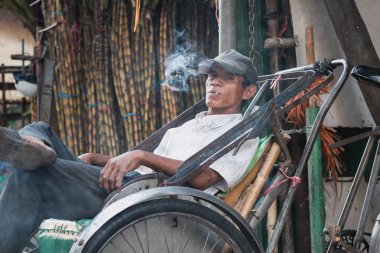 Phnom Penh, Kamboçya - 28 Ocak 2019: Bir bisiklet şoförü sokakta bisikletinin içinde sigara içiyor..