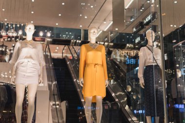 Ho Chi Minh City, Vietnam - 8 Ocak 2019: Vincom Center 'da bir H & M mağazasında, arka planda bir alışveriş merkezi olan, yazlık elbiseli kadın mankenler dükkanın vitrininde duruyor.