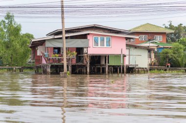 Bangkok, Tayland - 25 Eylül 2018: Chao Phraya Nehri 'nin üzerinde bir stilt ev. İşte bu kadar çok Taylandlı nehir kenarında yaşıyor..