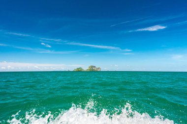 Tropikal adalara tekne gezisi (Ko Poda ve diğerleri), deniz ufkunda güzel gökyüzü, su püskürtme ile. Tipik bir deniz manzarası Ao Nang 'dan Railay Sahili' ne ya da Ko Poda 'ya gidiyor. Krabi Eyaleti, Tayland.