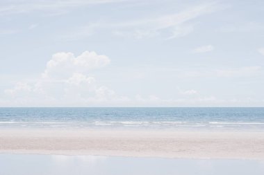 Gökyüzünde ve sahilde çeşitli bulut oluşumlarıyla deniz manzarası. Pastel gölgelerin yaz arkaplanı.