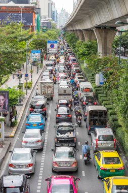 Bangkok, Tayland - 15 Haziran 2018: Sukhumvit Yolu 'ndaki trafik sıkışıklığı (Bts istasyonu Phrom Phong yakınlarındaki) yoğun trafiğin kötü şöhreti. Benchasiri Parkı solda, Bts ve beton sütunları. Dikey fotoğraf