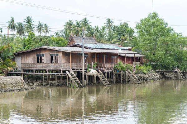 Wooden stilt house beside a river in Samut Songkhram province, Thailand. At a boat tour from Amphawa Floating Market.