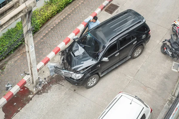 Bangkok, Tayland - 12 Aralık 2018: Bir araba sahibi arabasını boş bir arka sokakta elektrik direğine çarptıktan sonra arama yapar..