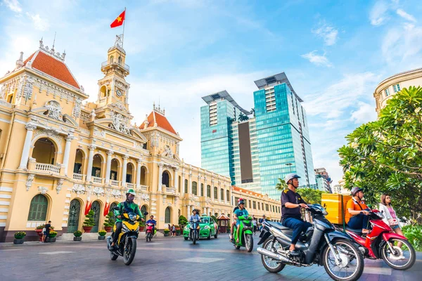 Ho Chi Minh City, Vietnam - 30 Nisan 2018: Saigon Belediye Binası, Vincom Merkezi kuleleri, inanılmaz mavi gökyüzüne karşı renkli sokak trafiği ve tropikal bitkiler. Saigon şehir merkezinin ünlü simgeleriyle.