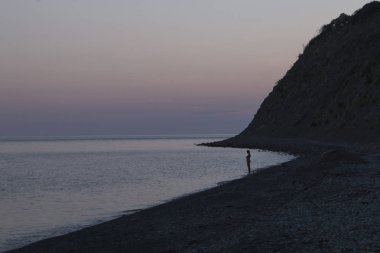 Gün batımında sahilde üzgün kız siluet