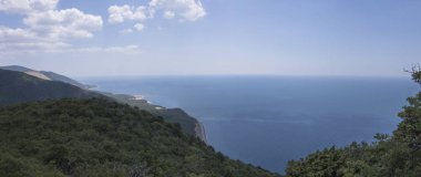 Dağlar, masmavi su, kumlu plaj ve mavi gökyüzü parlak güneşli bir günde, yaz yatay. Arka plan seyahat. Panorama