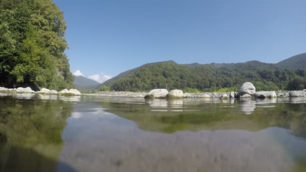 Landschaft mit Gebirgsbäumen und einem Fluss davor. Reflexion im Wasser. 4k — Stockvideo