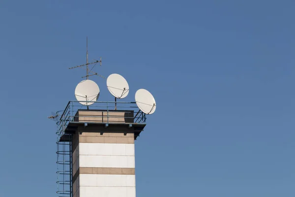 Satellit parabolantenn på toppen av byggnaden i stadsområde på solig dag. — Stockfoto