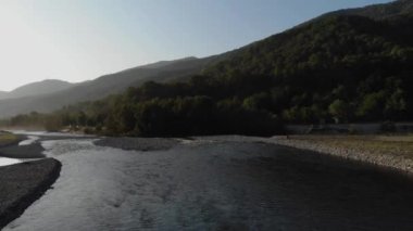 Nehrin havadan görünümü kıvrımları. Güzel nehir ve dağ üzerinde uçan, güneşli bir gün. Havadan insansız hava aracı atışı, manzara panoraması. 4k
