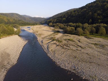 Güzel yeşil dağlar ve nehir üzerinde drone ile hava uçuş.