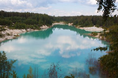çam ormanları arasında masmavi su ocağında yaz aylarında yansıyan bulutlar