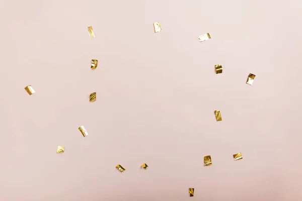 pembe bir arka plan üzerinde altın folyo parçaları. Üstten görünüm, düz yatıyordu. Metin için yer. Boşaltmak.