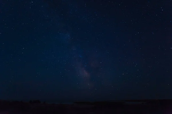 Samanyolu gece ufuk üzerinde pek çok parlak yıldız. Karanlık bir manzara. Arka plan metni