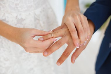 Portre alyans onların düğün töreni sırasında açık havada alışverişi çift. Damat gelini Parmağında alyans koyarak fotoğrafını kırpılmış.