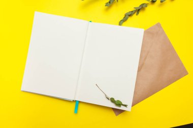Açık Not defteri ile kahverengi zarf ve Kağıt arka planda sarı renkteki kuru bitki flatlay. Tasarım için boşaltmak, yukarı alay