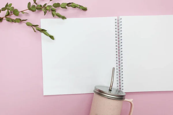 yaylar ve Kupası açık defter ile metal kap kuru bitkiler ile pembe bir arka plan üzerinde düz yatıyordu. Yukarı alay, tasarım için metin için yer