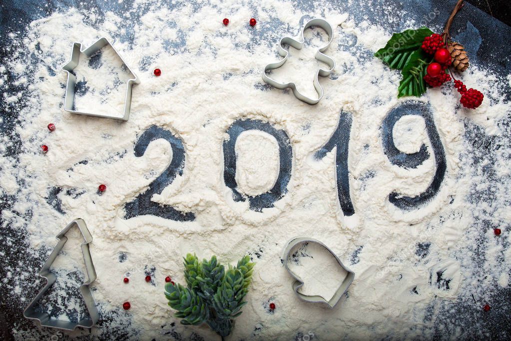 inscription 2019 on spilled flour on a dark background