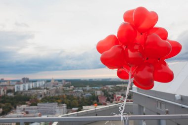 Kırmızı kalp şeklinde balonlar şehir manzaralı çatı demet