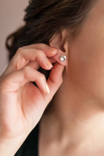 Zarif esmer gelin düğün için hazırlık küpe koyar. Yakın çekim